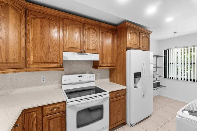 a kitchen with a refrigerator sink and cabinets