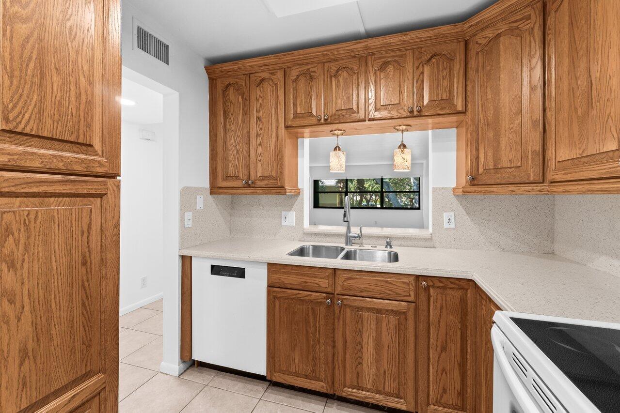 3014 Southwest 21st Terrace, Unit 352B Delray Beach, FL 33445 - Photo 10 of 26 a kitchen with stainless steel appliances granite countertop a sink and cabinets