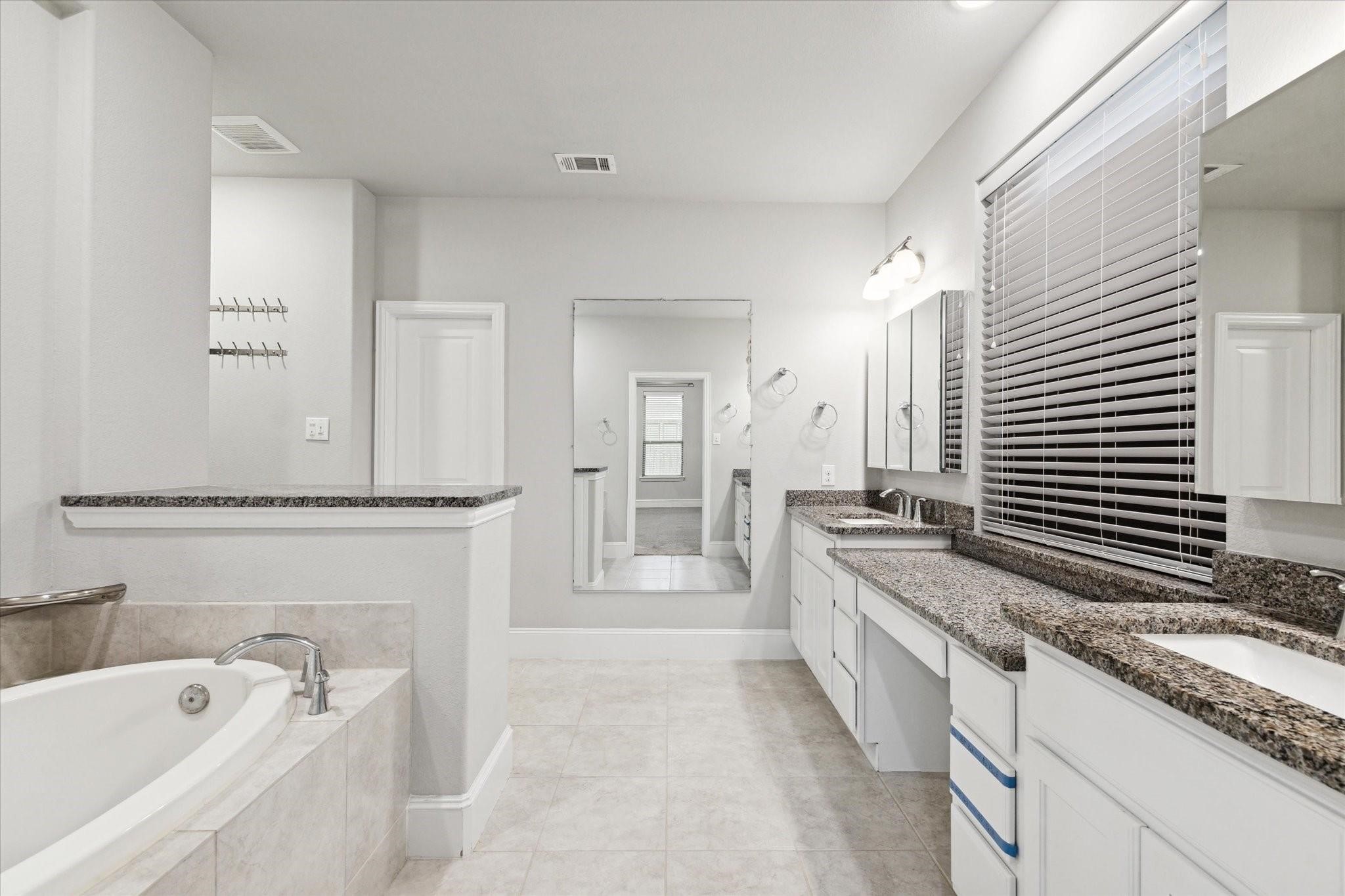 1010 Bat Hawk Court Conroe, TX 77385 - Photo 24 of 50 a spacious bathroom with a granite countertop tub sink and mirror