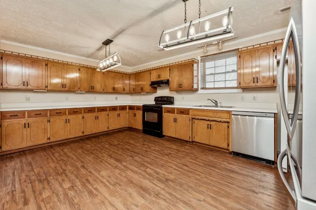 a kitchen with cabinets a sink and appliances