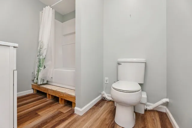 a bathroom with a toilet and a shower