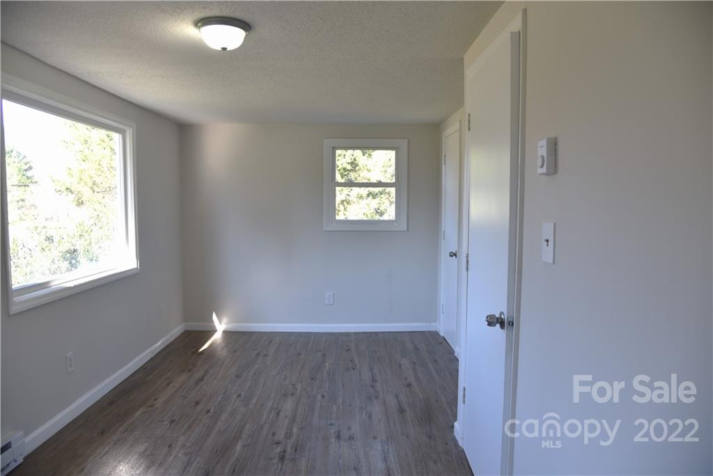458 Kimmon Road Harmony, NC 28634 - Photo 12 of 23 an empty room with wooden floor and windows