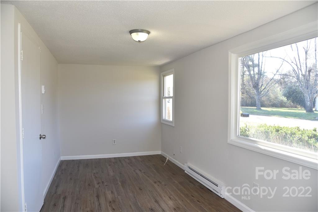 458 Kimmon Road Harmony, NC 28634 - Photo 13 of 23 an empty room with wooden floor and windows