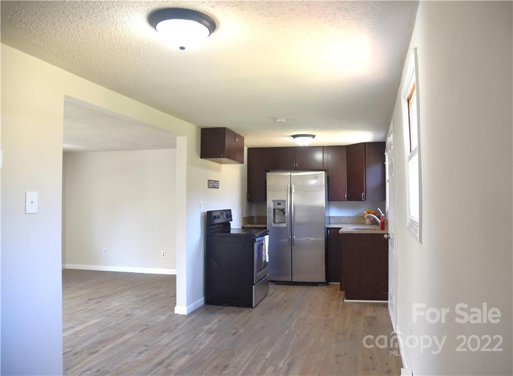 458 Kimmon Road Harmony, NC 28634 - Photo 5 of 23 an empty room with wooden floor cabinet and windows