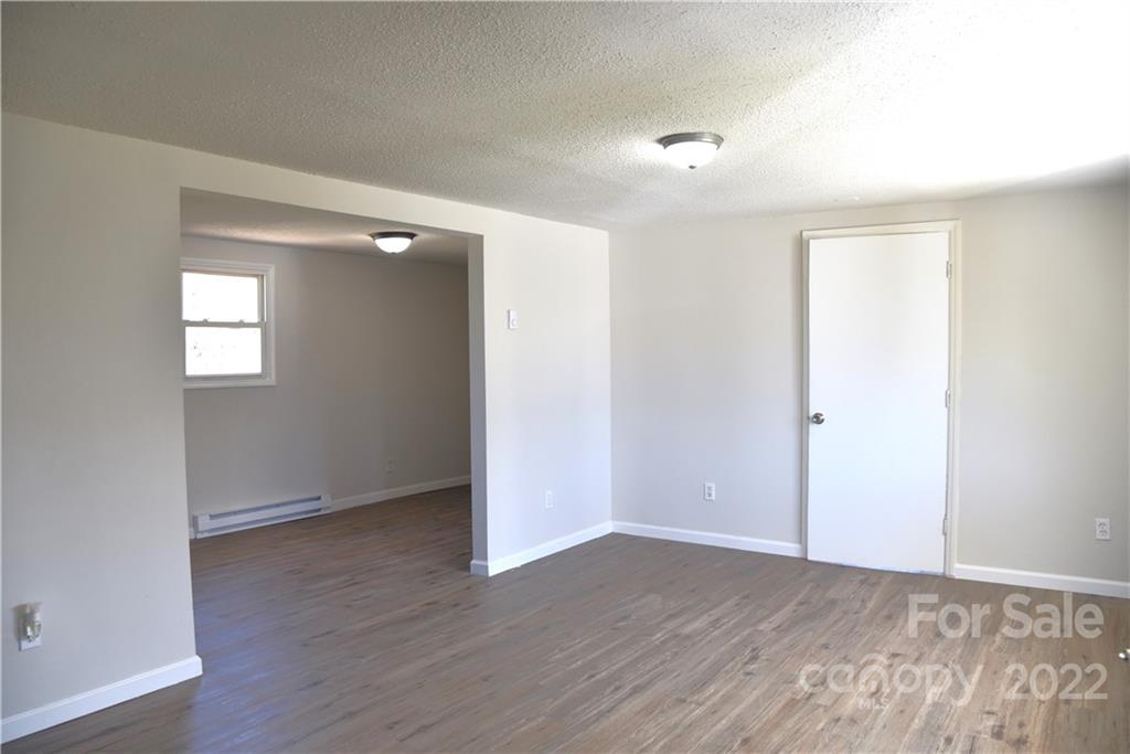 458 Kimmon Road Harmony, NC 28634 - Photo 7 of 23 an empty room with wooden floor and windows