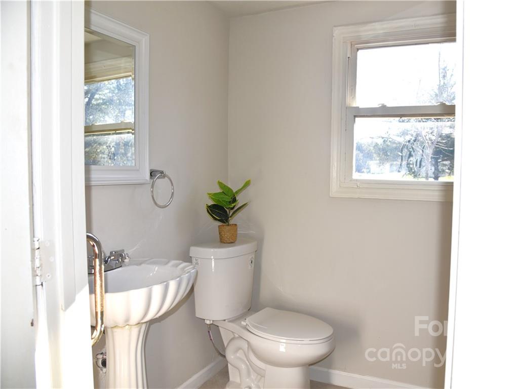 458 Kimmon Road Harmony, NC 28634 - Photo 9 of 23 a white toilet sitting next to a window and vanity