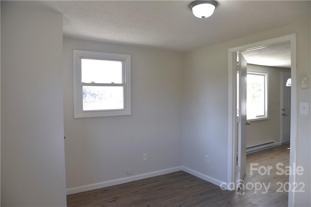 458 Kimmon Road Harmony, NC 28634 - Photo 10 of 23 an empty room with wooden floor and windows