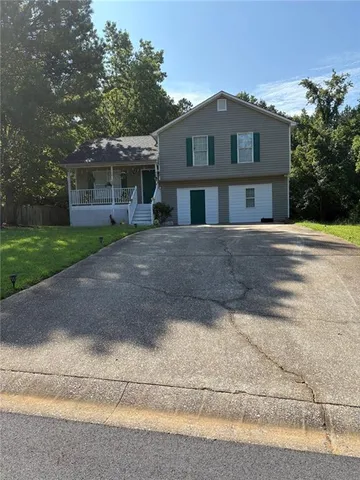 a front view of a house with a yard and trees