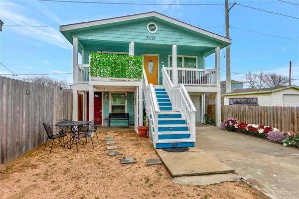 a view of a patio with table and chairs with wooden fence and plants