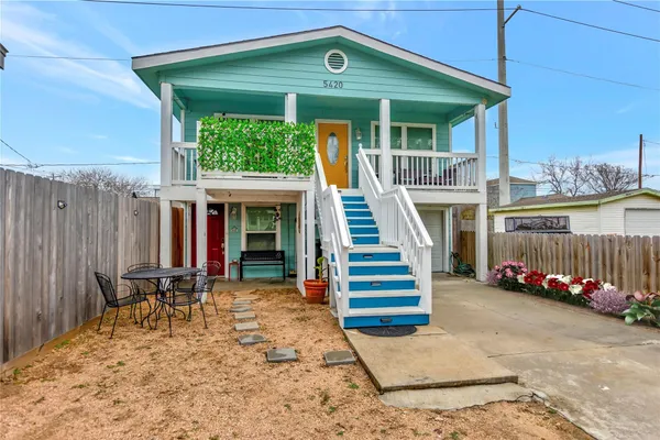 a view of a patio with table and chairs with wooden fence and plants