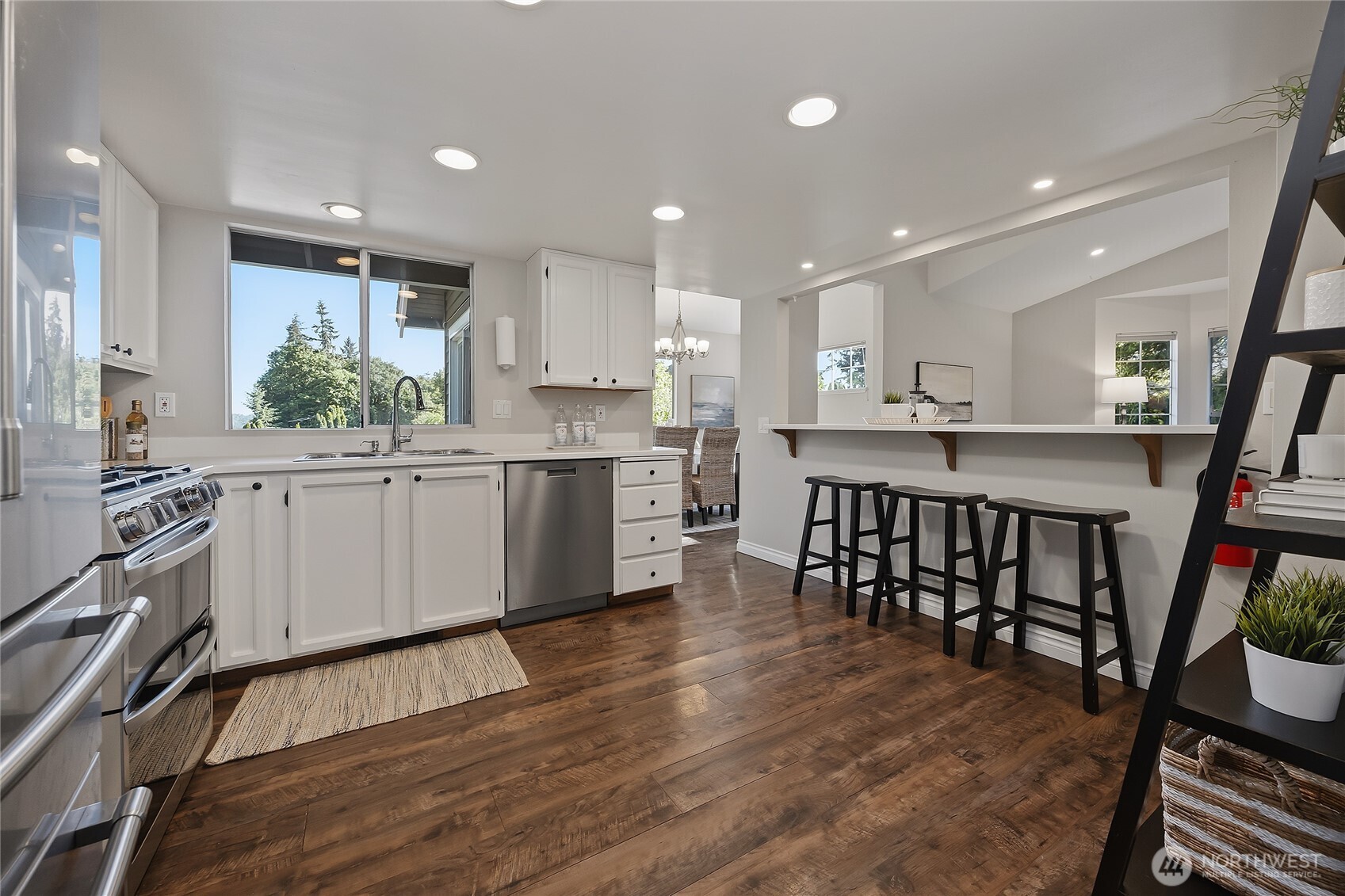 23707 Meridian Place West Bothell, WA 98021 - Photo 14 of 40 a large kitchen with stainless steel appliances granite countertop a stove a sink a refrigerator and white cabinets with wooden floor