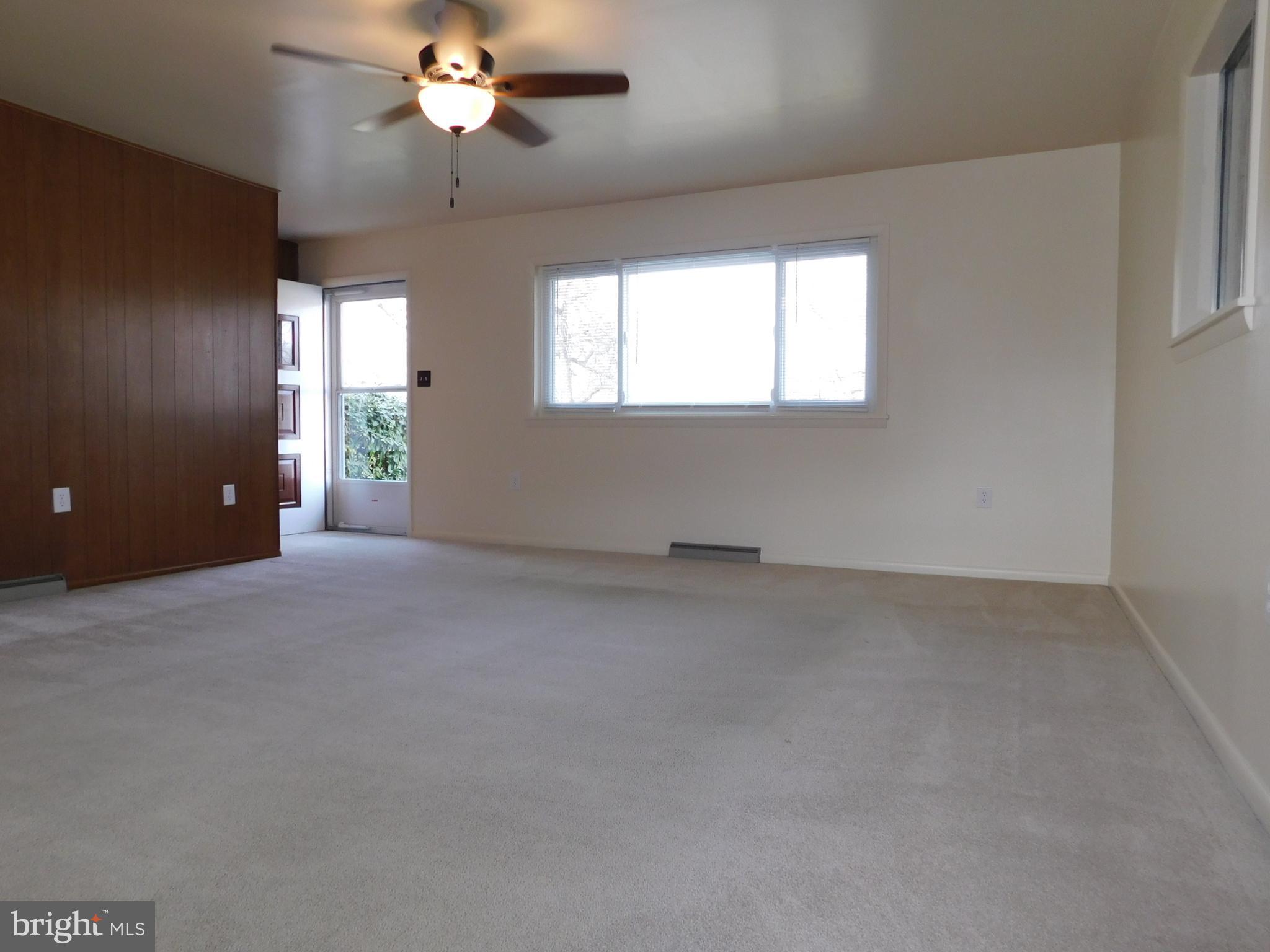 1569 Frank Road Chambersburg, PA 17202 - Photo 4 of 18 an empty room with a chandelier fan and windows