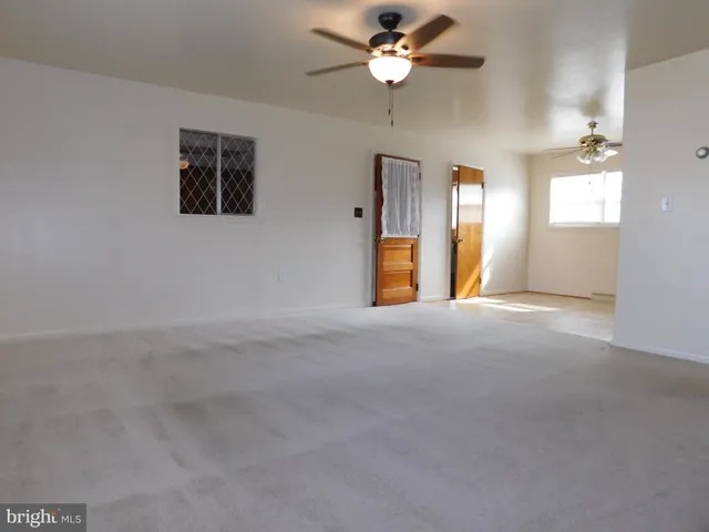 en empty room with windows and fan