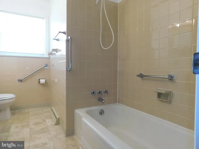 a bathroom with a white bath tub and a shower