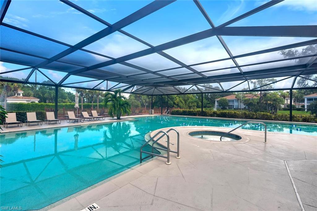 6899 Rain Lily Road, Unit 103 Naples, FL 34109 - Photo 31 of 39 Community pool with an in-ground hot tub, a patio area, a sunroom, and glass enclosure
