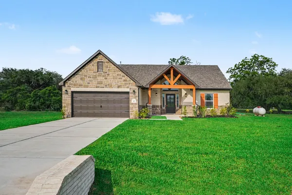 a front view of a house with yard and green space