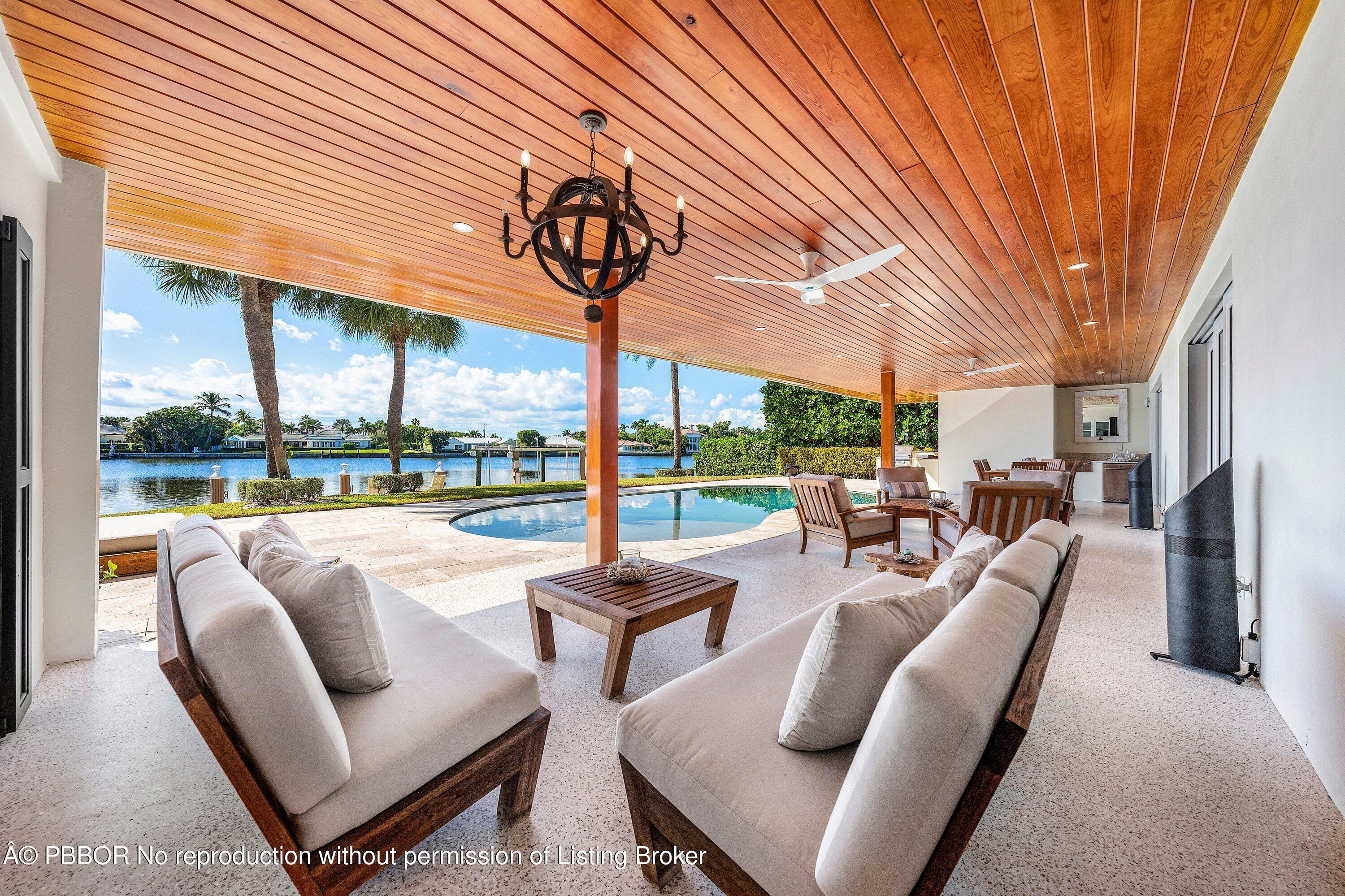 50 Spoonbill Road Lantana, FL 33462 - Photo 20 of 37 a view of a patio with couches chairs under an umbrella