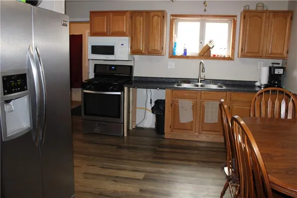 a kitchen with stainless steel appliances granite countertop a microwave a stove and a refrigerator