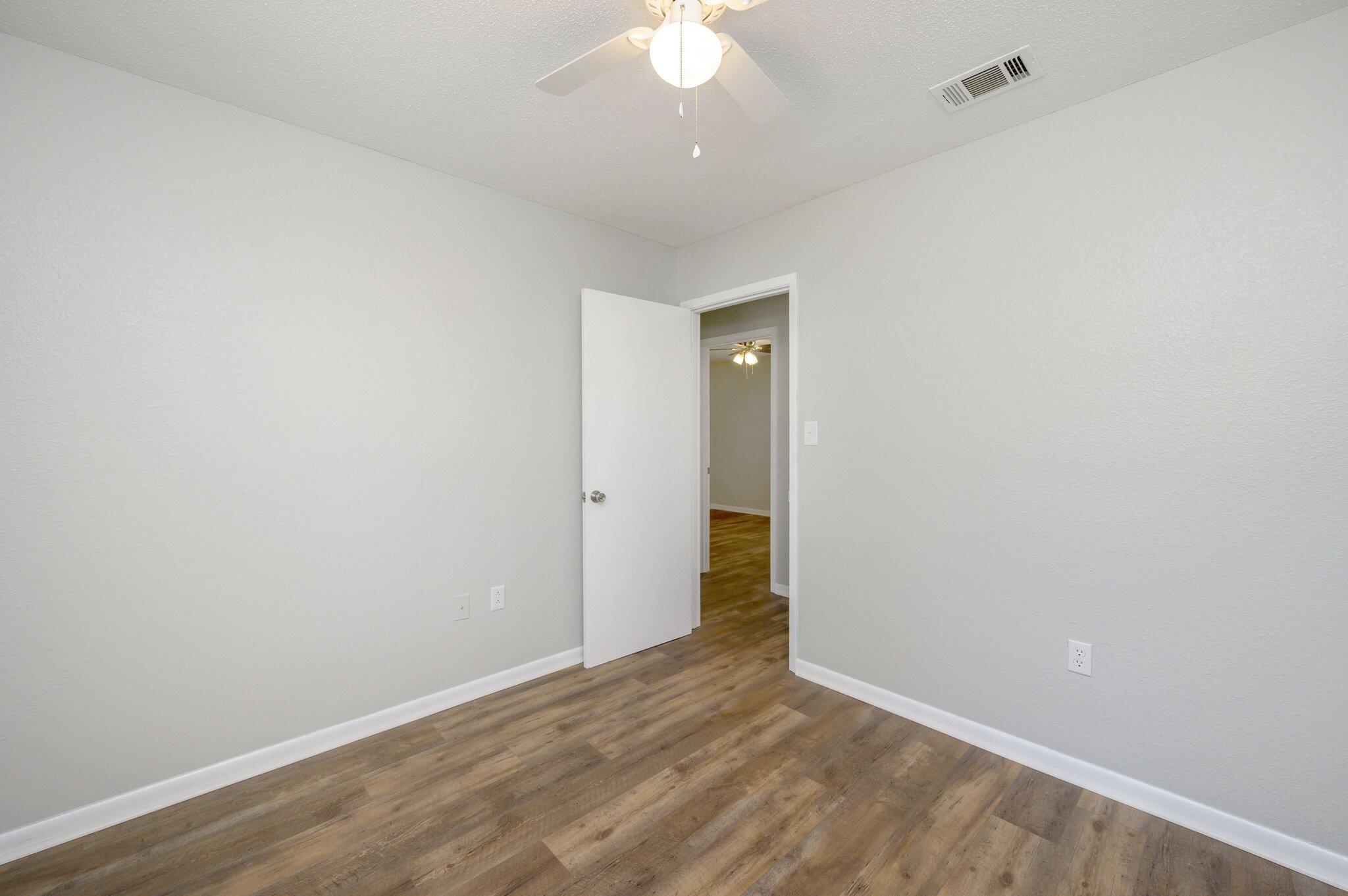 3970 Indian Mound Road Crestview, FL 32539 - Photo 16 of 33 a view of an empty room with wooden floor and a ceiling fan