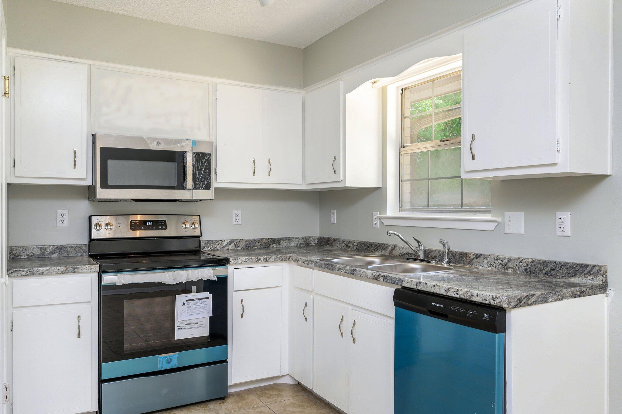 3970 Indian Mound Road Crestview, FL 32539 - Photo 8 of 33 a kitchen with granite countertop a stove a sink and a microwave