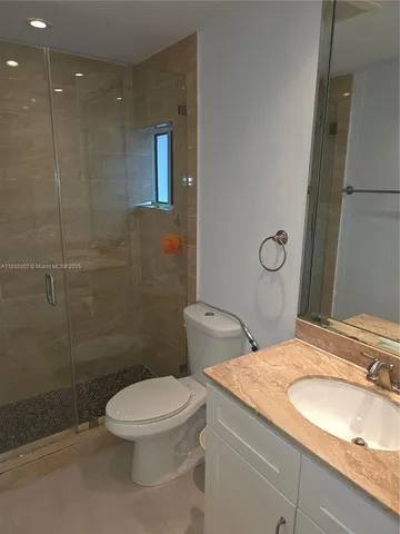 a bathroom with a granite countertop toilet a sink and a shower