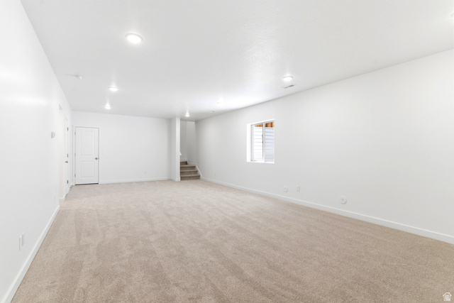 7243 West Terraine Road West Jordan, UT 84081 - Photo 25 of 31 Spacious open area featuring neutral-toned carpet, recessed lighting, and a window with blinds