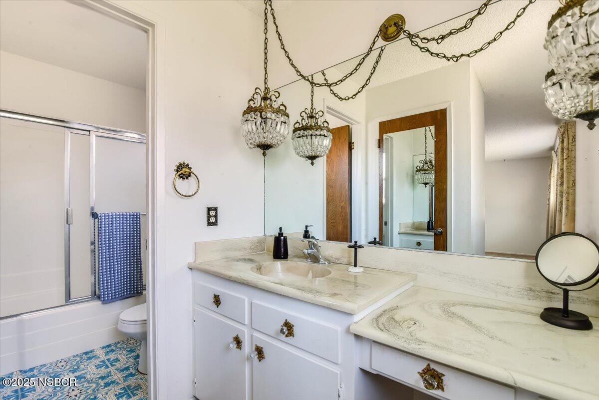 244 Pegasus Avenue Lompoc, CA 93436 - Photo 17 of 28 a bathroom with a granite countertop sink and a mirror