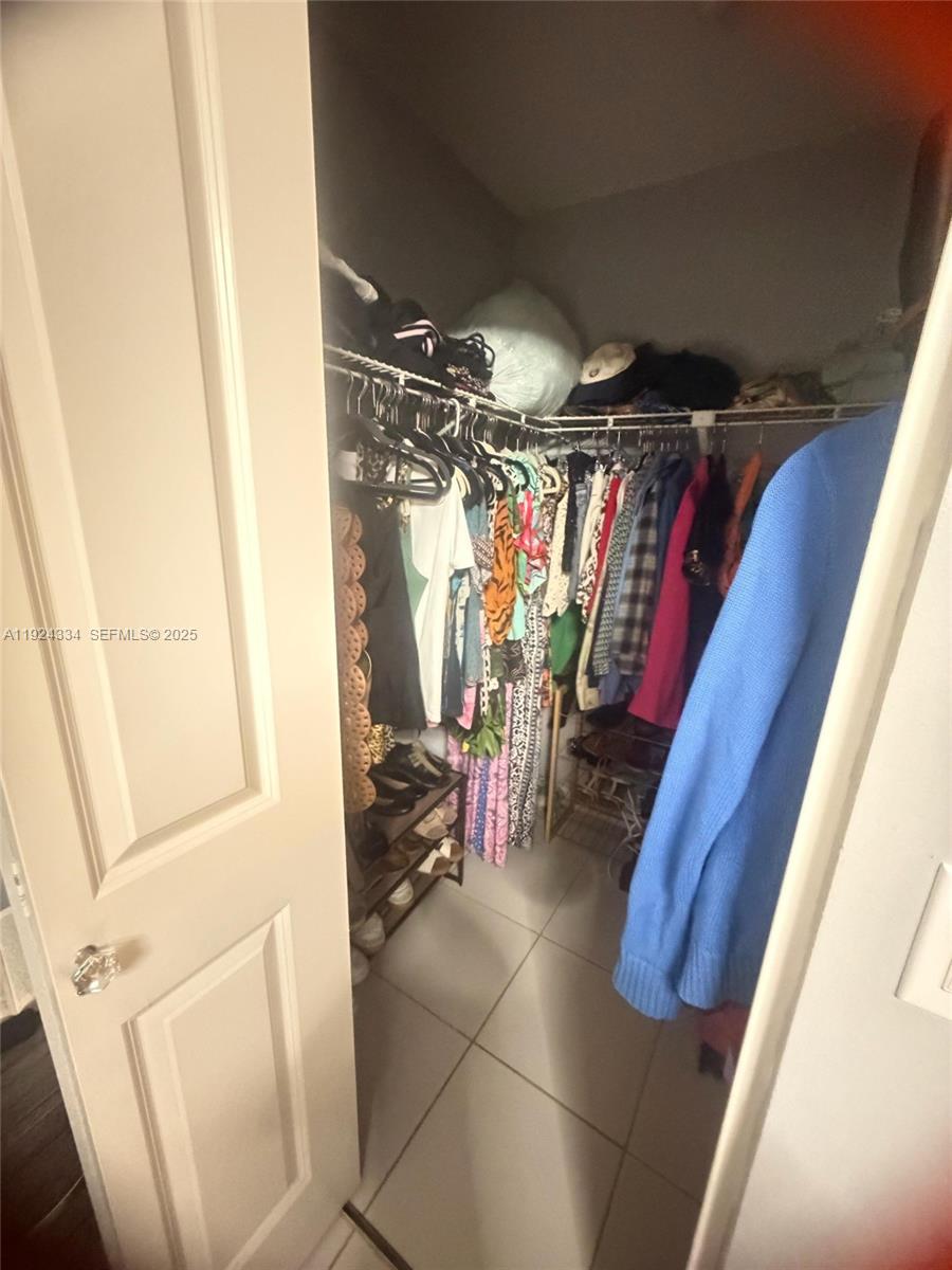 3001 Northwest 4th Terrace, Unit 158 Pompano Beach, FL 33064 - Photo 19 of 23 a view of walk in closet with clothes and shoes