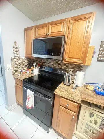 a kitchen with stainless steel appliances granite countertop a sink stove and microwave
