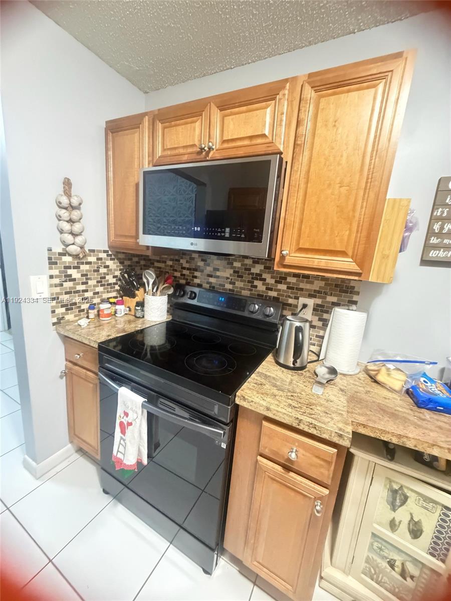3001 Northwest 4th Terrace, Unit 158 Pompano Beach, FL 33064 - Photo 2 of 23 a kitchen with stainless steel appliances granite countertop a sink stove and microwave