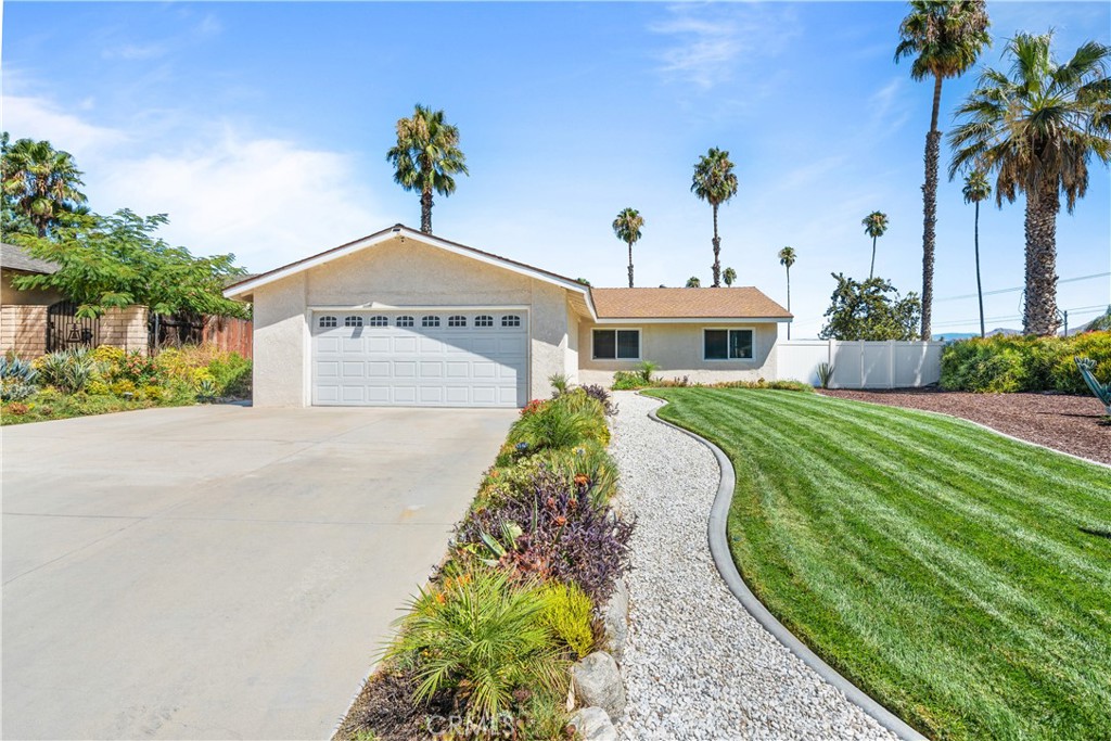 a front view of a house with a yard and potted plants