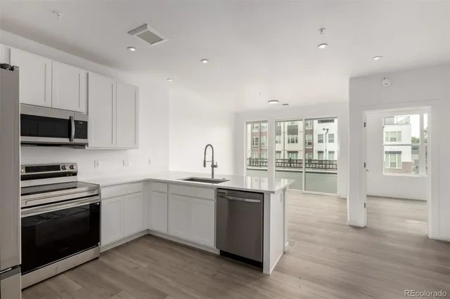 a kitchen with granite countertop white cabinets and stainless steel appliances