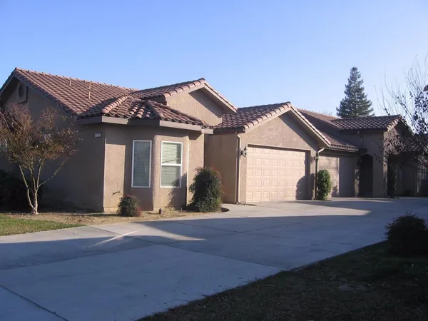 a front view of a house with a garden and yard