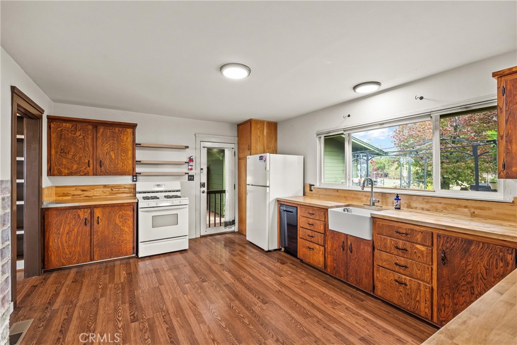 5416 Foster Road Paradise, CA 95969 - Photo 13 of 30 a kitchen with granite countertop a refrigerator and wooden floors