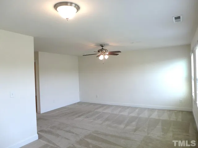 an empty room with a ceiling fan and a window