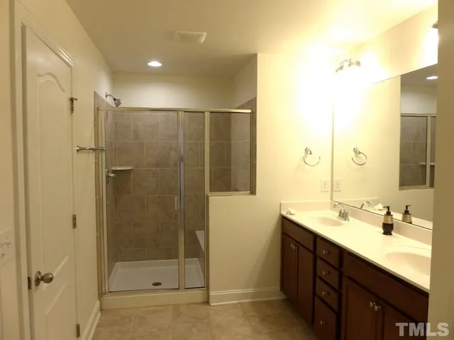 a bathroom with a shower sink and mirror