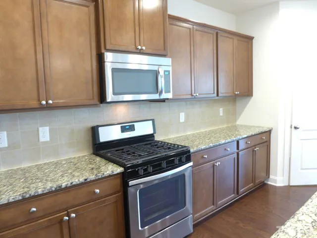 a kitchen with granite countertop cabinets and steel stainless steel appliances