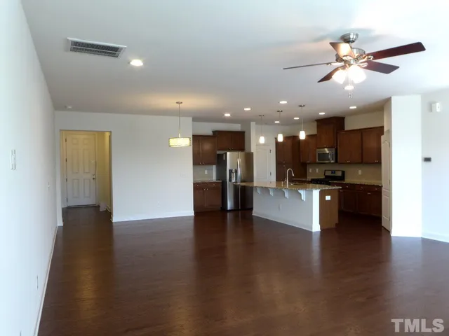 a view of a kitchen and a livingroom with furniture wooden floor and a kitchen