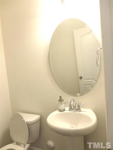 a bathroom with a sink and mirror with toilet