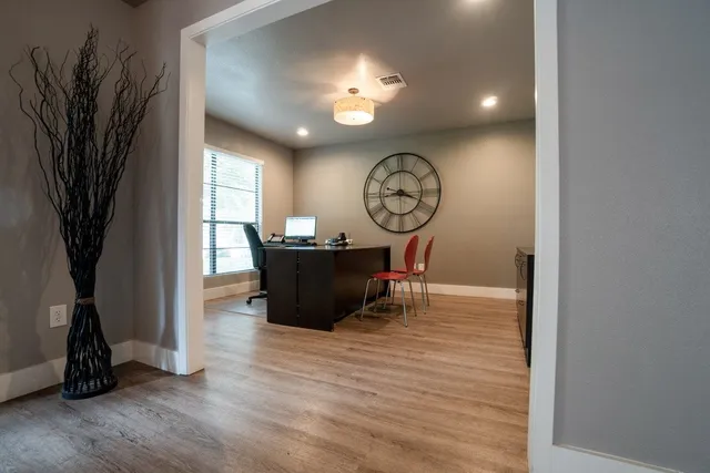 a living room with furniture floor to ceiling window hardwood floor and a flat screen tv