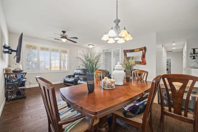 a dining room with furniture a chandelier and wooden floor
