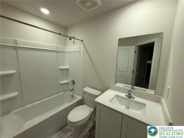 a bathroom with a sink toilet vanity and shower