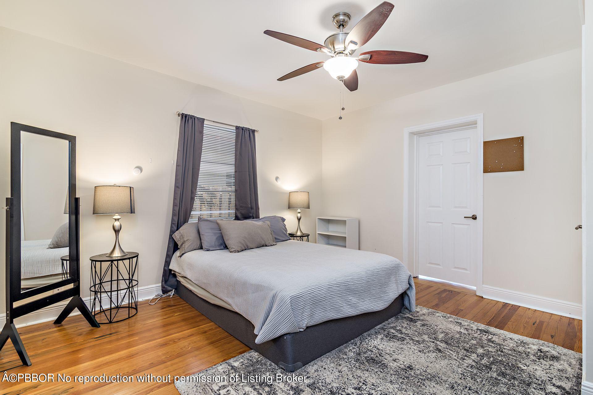 816 Sunset Road West Palm Beach, FL 33401 - Photo 14 of 22 a bedroom with a bed chandelier and a window