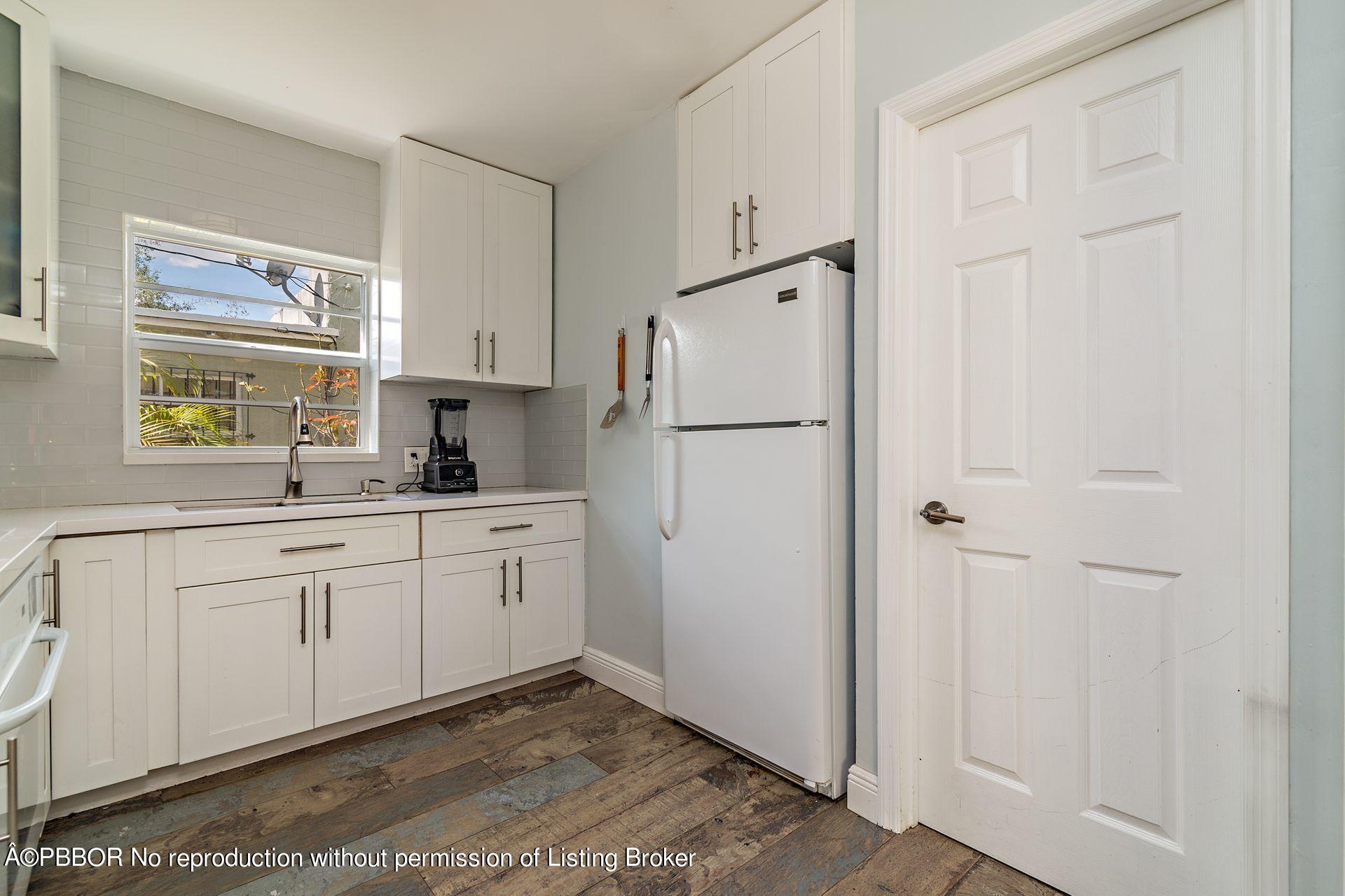 816 Sunset Road West Palm Beach, FL 33401 - Photo 10 of 22 a kitchen with white cabinets and white appliances