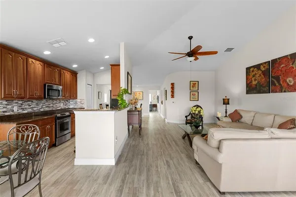 a living room with furniture appliances and wooden floor