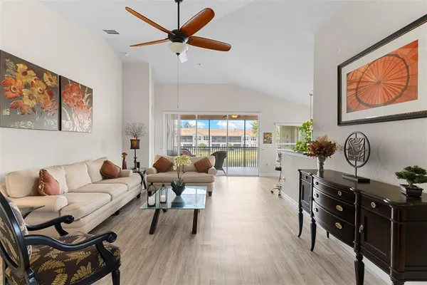 a living room with furniture a ceiling fan and a window