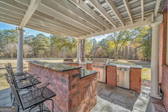 a view of a patio with table and chairs with wooden floor and fence