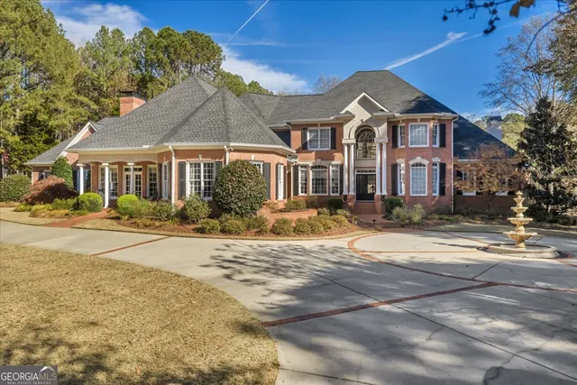 a view of a house with a small yard and a large tree