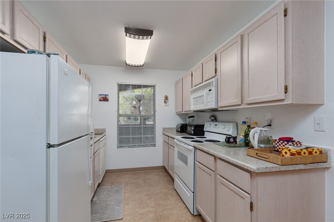 231 West Horizon Ridge Parkway, Unit 1126 Henderson, NV 89012 - Photo 8 of 33 Kitchen with white appliances, light countertops, and light tile patterned flooring