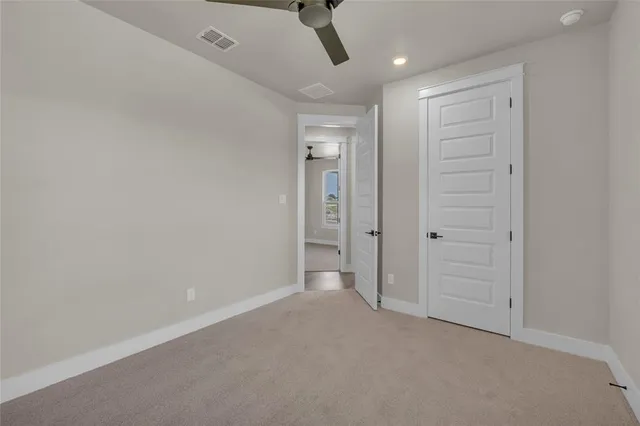 an empty room with a window and ceiling fan